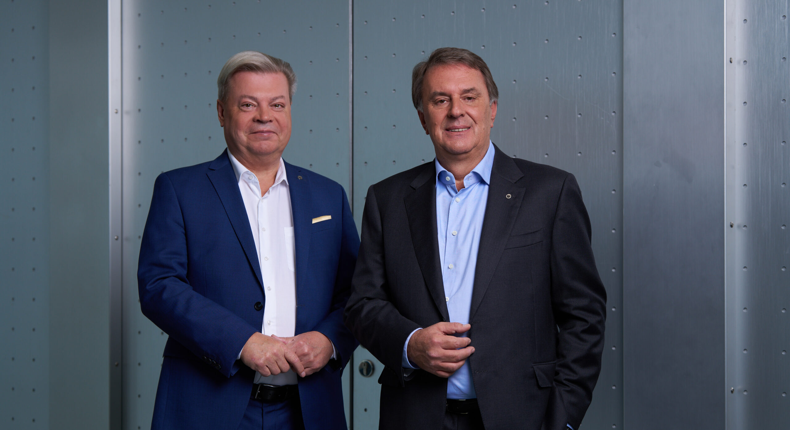 Harald Servus links im blauen Anzug rechts davon Wolfgang Ecker im dunklem Anzug vor einer Stahltür in grau