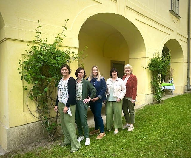 Eröffnungsfeier bei HairMotion in Baden: Drei Personen bei der feierlichen Übergabe einer „Viel Glück“-Karte und eines Schlumberger-Geschenks im modernen Studio.