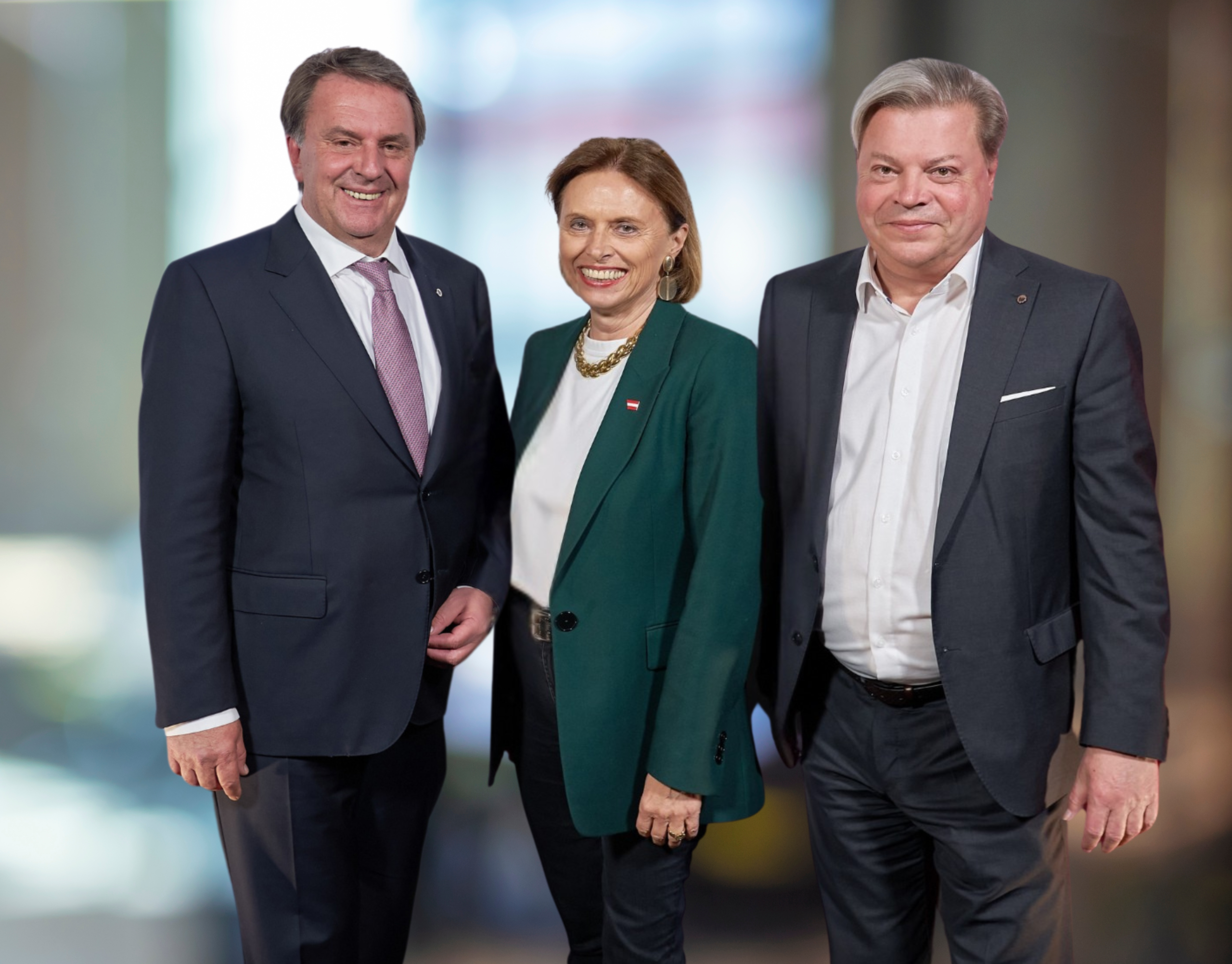 Ecker im dunklem Anzug in der Mitte Kraus WInkler im grünem Blazer daneben rechts Harald Servus im dunklem Anzug. Der Hintergrund ist verschwommen