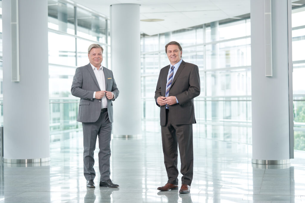 Harald Servus im grauen Anzug und rechts neben ihn Wolfgang Ecker im dunklen Anzug