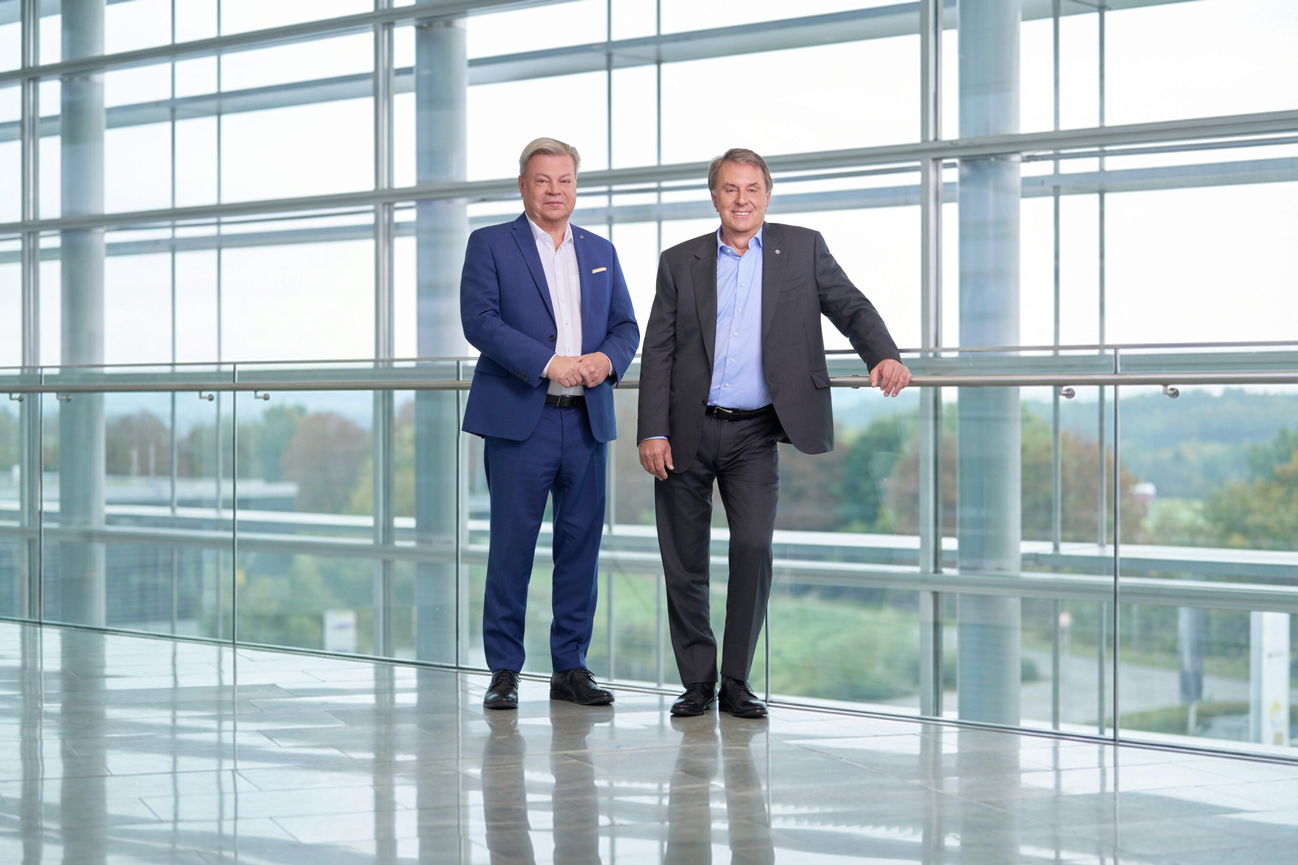 Harald Servus im blauen Anzug links vor einer Glasfront, rechts neben ihm im dunklem Anzug Wolfgang Ecker