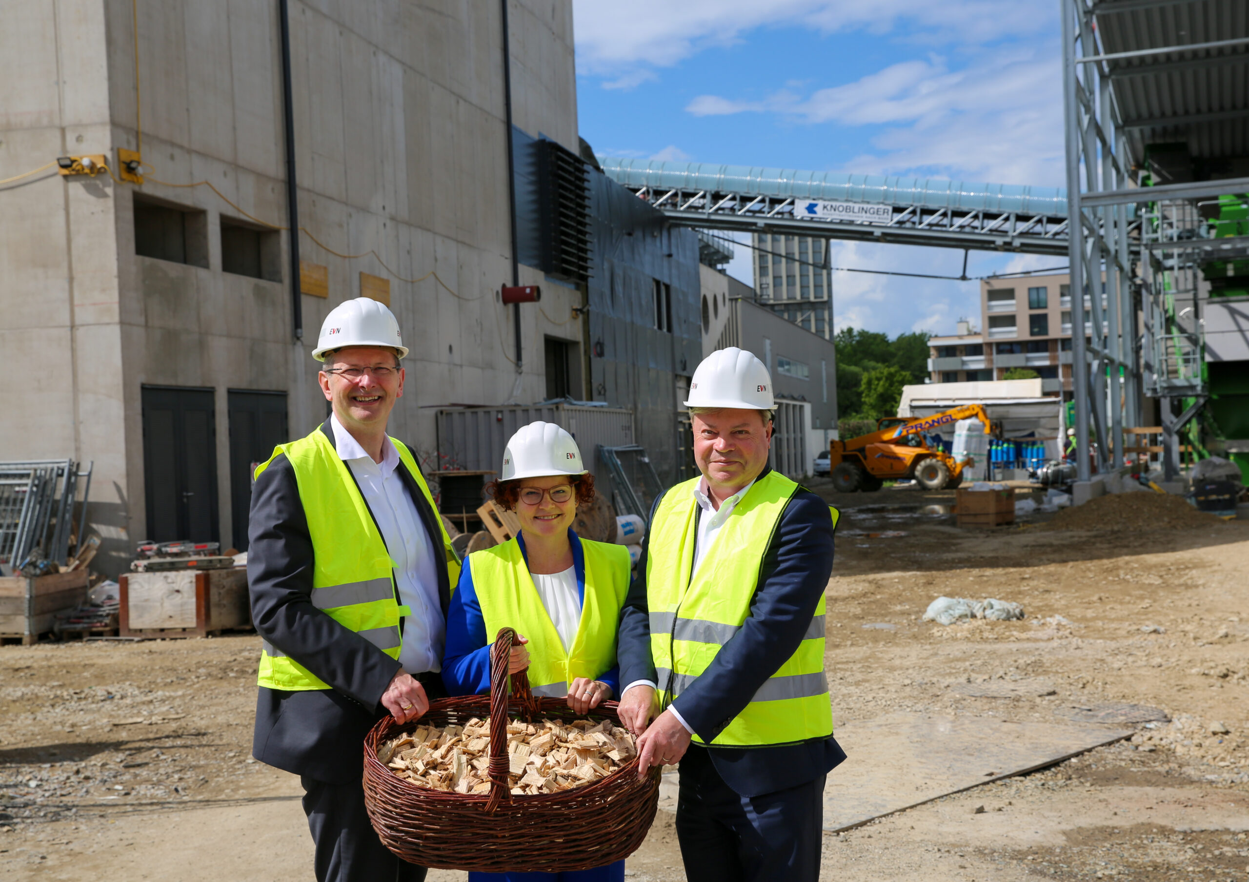 links Stefan Stallinger, in der Mitte Elisabeth Zehetner und rechts Harald Servus, alle mit gelber Warnweste und Helm auf der Baustelle