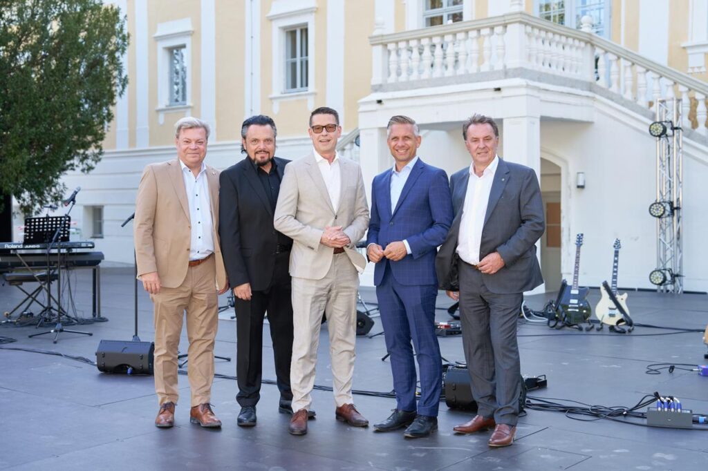 Harald Servus im hellen Anzug mit Werner Auer im schwarzen Anzug, daneben Kurt Hackl im hellen Anzug, neben ihm Wolfgang Hattmannsdorfer im blauen Anzug und rechts Wolfgang Ecker im grauen Anzug auf der Bühne vor dem Schloss Haindorf